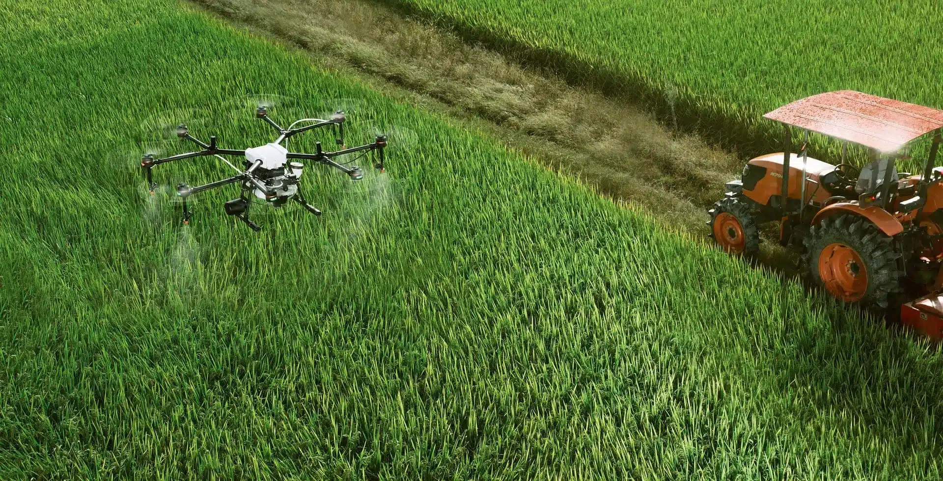 Drohne bewässert Feld daneben ein Traktor